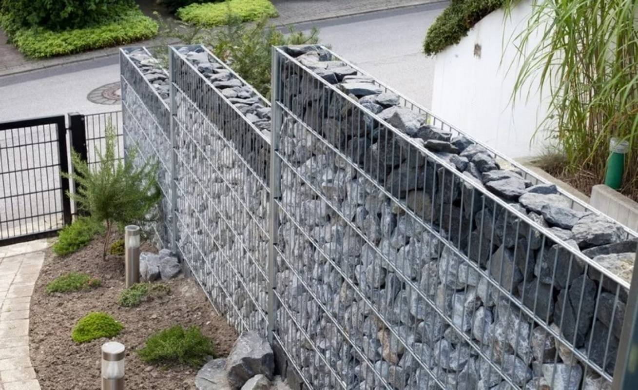 Забор из камня (58 фото): каменная ограда в сетке, варианты из декоративного камня и бута